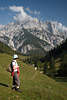 913312_Bergwanderer Photos Frau auf grüner Almwiese vor imposanten Felsbergen & Talblick