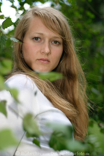 Maedchen im Blattgewirr erotisches Portrait in Wind langblondes Haar