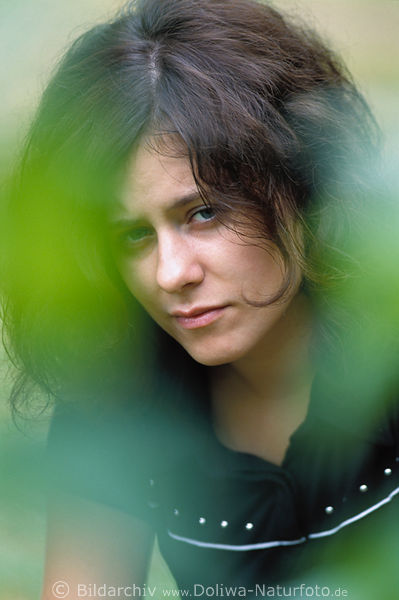 Mdchen hbsch dunkelhaarig Portrt in verwischtem Grn Frau flliges Schwarzhaar