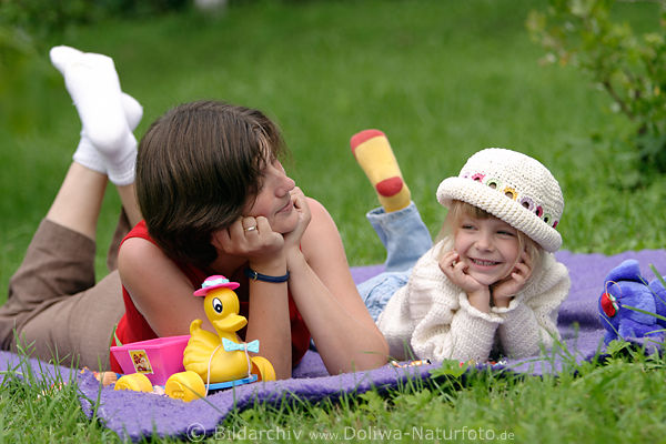 Frau mit Kind Portrait auf Wiese Decke liegen blondes Kindchen in Mtze lcheln