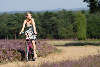 Mdchen mit Fahrrad radeln in Heide Rad-Wanderweg blhende Erika-Landschaft