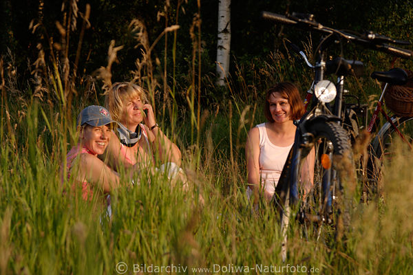 Radlerinnen Rast in Grser Frauen am Wald Trio Naturportrt lachend bei Picknick auf Wiese