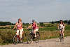 57366_Frauen Trio mit Rad unterwegs auf Feldweg