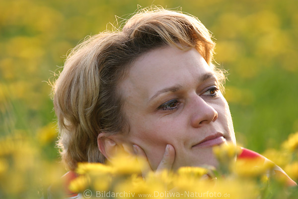 Frau in Wildblumen Foto, hbsches Mdchen Kopf Grobild in Bltenfeld getaucht in warmen Frhlingssonne