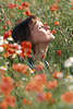 Frau in Blumenfeld Klatschmohn-Blüten Kraft schöpfen Natur fühlen sonnen