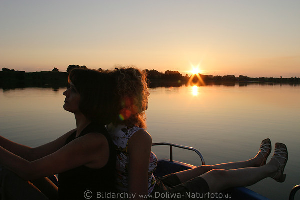 Mdels Duo bei Sonnenuntergang ber Wasser-Seetafel romantische Abendstille