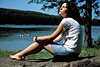 3769_Mädchen bei Sonnen Fotos, Sonnenbad am Seeufer, Schwarzhaarige auf Stein sitzen im Sonnenschein