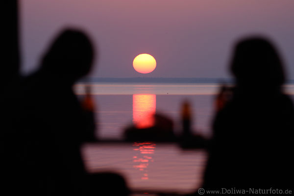 Paar Silhouetten vor Sonnenball ber See Romantik Wasserblick