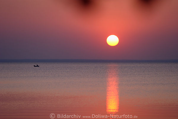 Sonne ber Seewasser rosarot Abendfarben mit Fischerboot