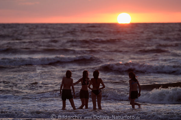 Badende Mdchen in Meer Wasserwellen vor Sonne am Horizont