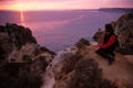 Mädchen am Felsen Meerküste in Sonne Gegenlicht romantische lila-violett Seepanorama