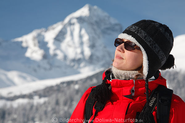 Mdel Gesicht vor Berg Schnee in Rotjacke Kopfmtze dicken Pulloverkragen