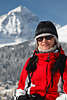 901209_Mädchen im Winter Freizeitkleid Porträt in knallroten Winterjacke vor weissem Berg lachen in Sonnenschein