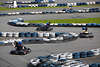 1100211_ Kartfahrer in Karts auf Kartbahn schlngeln zwischen Autoreifen bei Kartrennen Fotografie