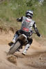 Motocrosser gibt Gas in Kurve fliegender Sand