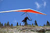 1202404_Drachenanflug Bild über Berghang schweben Pilot mit Segeldrache Hängegleiten Flugstart