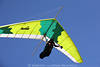 1202431_Hell buntes Drache Flugbild grün gelb weiß am Blauhimmel Pilotfoto am Steuerknüppel