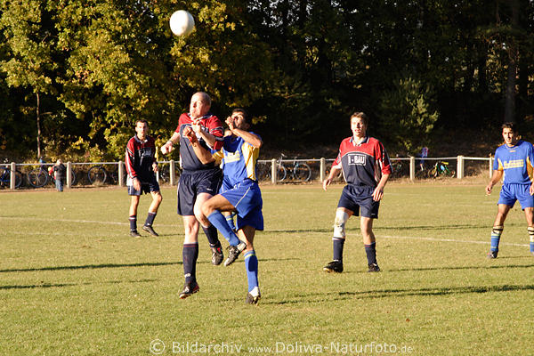 Fussball Kopfball, Kopfballduell bei Fuball im Sonnenschein, Kicker in Aktion