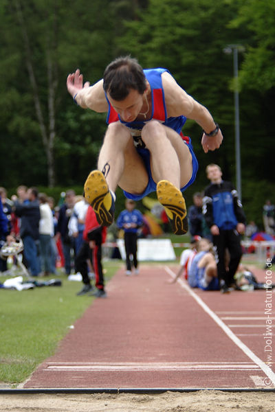 Weitspringer Sprungflug in Leichtathletik Sandkasten