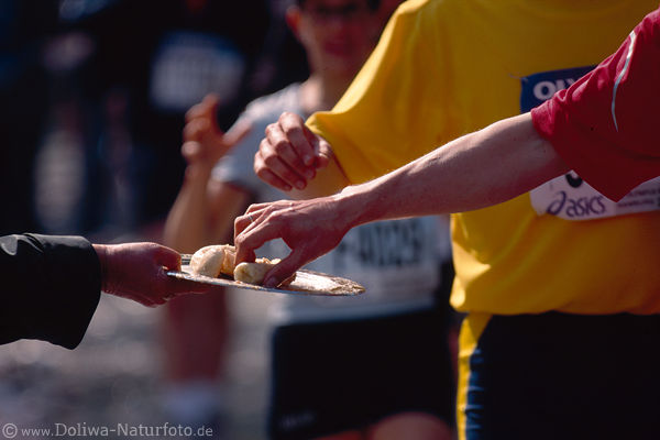 Laufkost Marathonlufer Hnde in Bild greifen Banane vom Tablett Laufnahrung Foto
