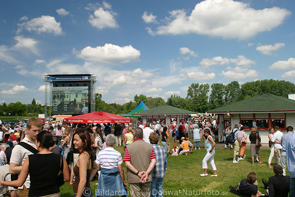 Pferdewetten auf Wiese Galopp-Rennbahn Foto Wettannahmestelle Spieler vor Leinwand