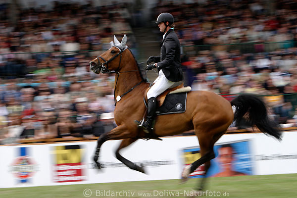 Pferderitt in Bewegung Foto 703283 Springreiter Dynamikbild vor Derby Publikum in Unschrfe