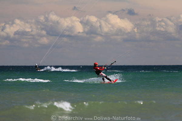 Kitesurfer auf See an Ostseek�ste brettern �ber Wellen in Wind unter Wolken
