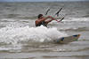Kitesurfer schräg in Wellengischt Foto Wasserfahren fast liegend in Nordseewasser