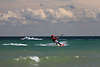 802720_ Kitesurfer auf See an Ostseeküste brettern über Wellen in Wind unter Wolken in Sportbild