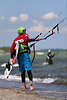802729_ Kitesurfer mit Surfbrett Sportbild an Seeküste in Wasser spazieren