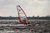700999_ Surfer auf Surfbrett ber Wasserwellen der Elbe surfen, brettern in Wind mit Segel in Hand ber Wasser