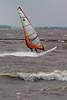 700979_ Surfer mit Windsegel über Elbe Wasser gleiten, brettern auf Brett mit Segel in Händen, Windsurfer Foto