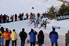 815956_Frauen Biathletinnen Gruppe im Biathlon-Staffelbewerb in Kurve an Zuschauerspalier Foto auf Skiloipe
