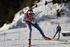 816252_ Biathlet frontal Skilauf Foto im Skatingstil auf schneeweissen Loipe mit Gewehr auf Biathlonstrecke