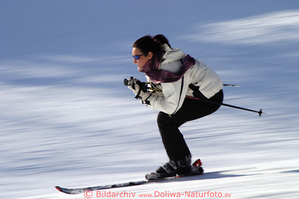 Skifahrerin Frau auf Schneepiste schnelle Fahrt bergab Bewegung