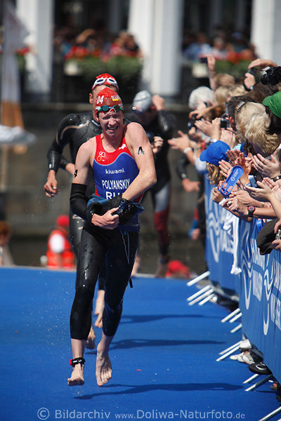 Dmitry Polyansky Russe bei Triathlon Hamburg auf Blauteppich vor Publikum Laufbild beim Umziehen