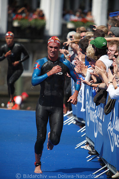 Triathlon WM James Elvery aus Neuseeland am Publikum in Schwimmanzug rennen auf Blauteppich