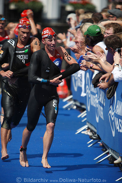 Steven Sexton USA Triathlet in Schwimmanzug rennen auf blau Laufteppich