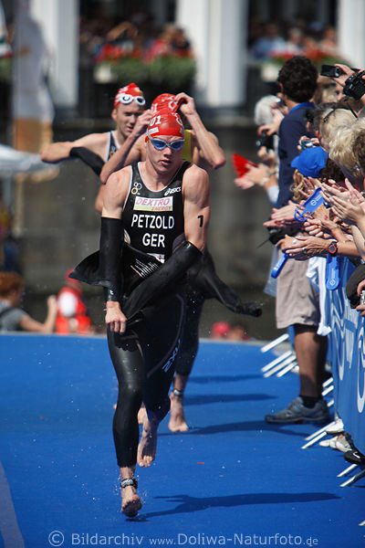 Deutscher Triathlet mit Nr.1 Maik Petzold Laufbild auf Blauteppich nach schwimmen in der Alster
