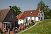 802605_Deichhäuser Foto, Greetsiel Sielstraße, Wohnidylle am Deich, Nordseeküste, Ostfriesland grüner Frühling