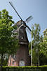Hinte historische Windmühle Flügel Galerie Dorfzentrum grüne Bäume Hochformat