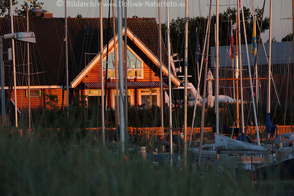 Niendorf Yachthafen Segelmaste Foto Holzhaus Ostsee Restaurant in Rotlicht Abendsonne