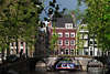 Amsterdam Leidsegracht Bogenbrücke mit Menschen Boot FrühlingsSonne Foto vor Altstadthäuser