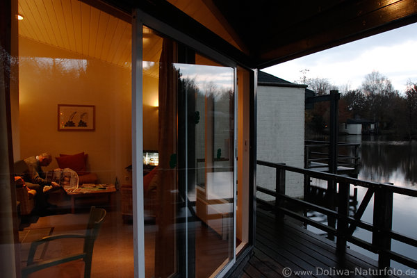 Bungalow Innen Auen Glaswand Holzbalkon Ausblick auf Wasserlandschaft