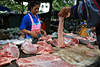 Thaimarkt in Bangkok, Thai Verkäuferin & Käufer am Marktstand mit Fleisch, Schweinefleisch